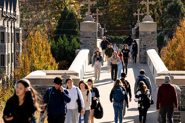 Students walking across bridge on campus