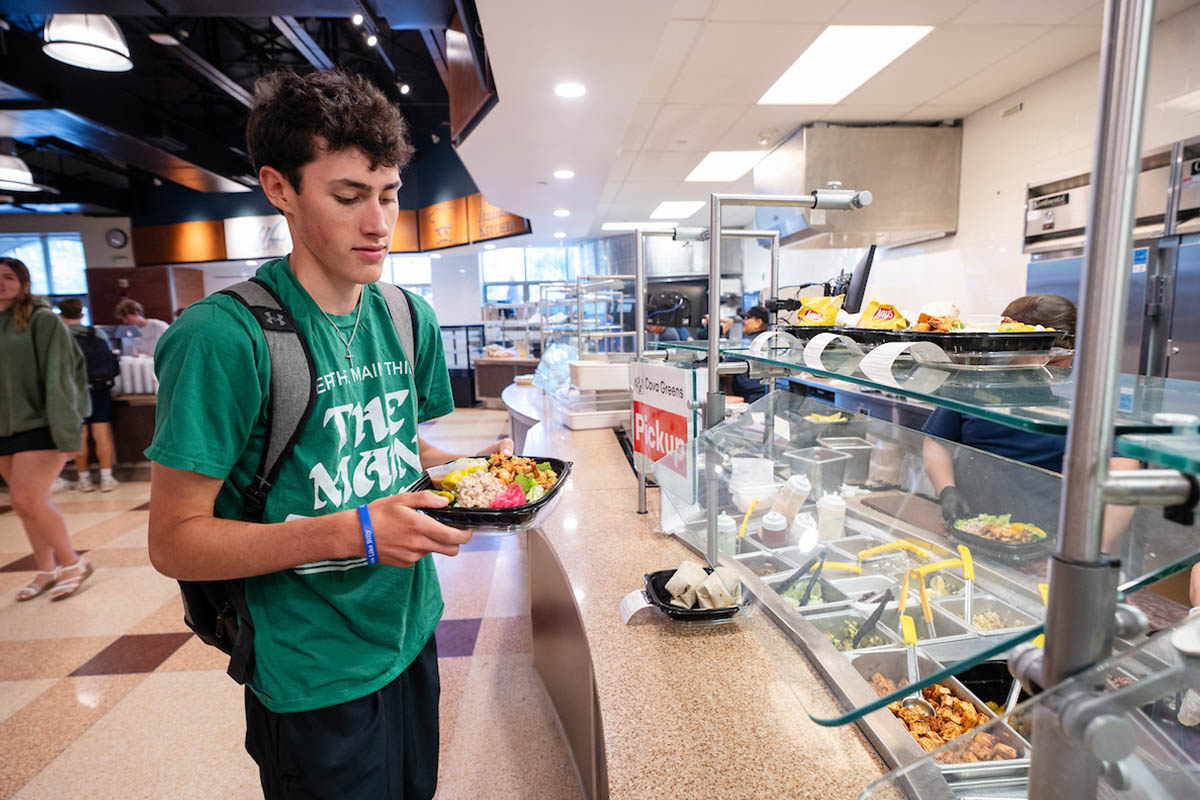 A student grabbing lunch from a buffett