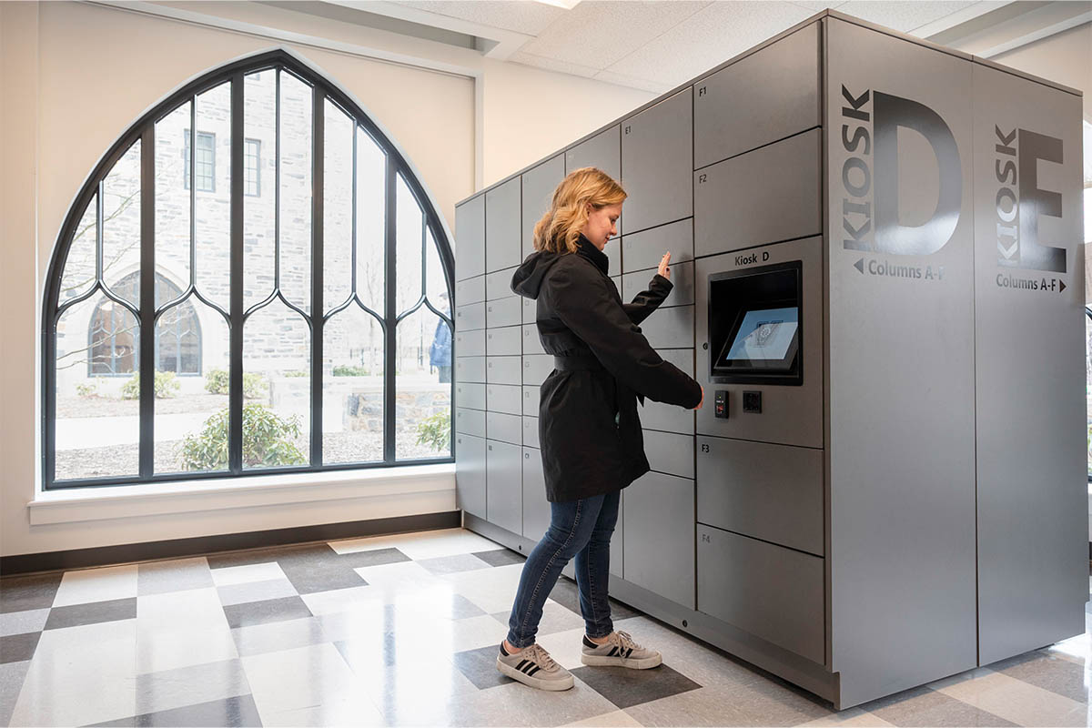 A student grabbing her mail from a campus mailbox