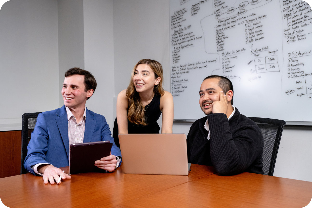 Three students in front of laptop