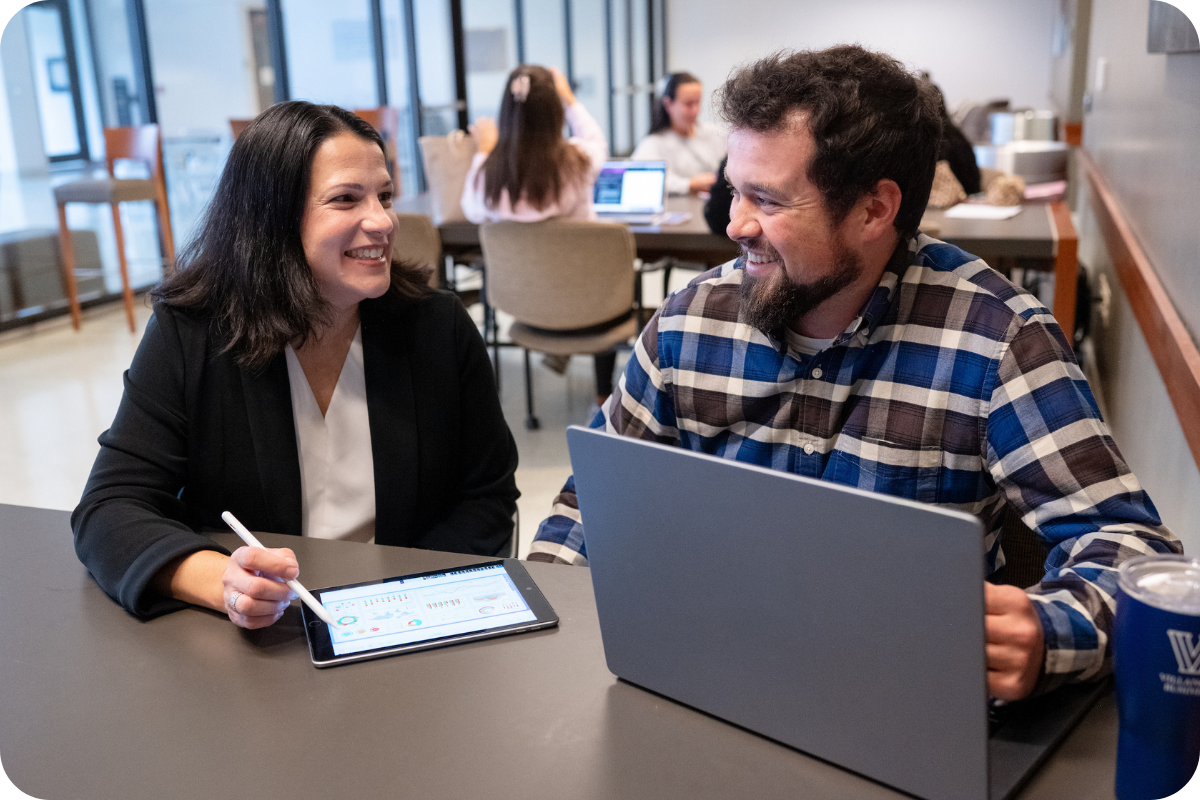 two students talking over laptop