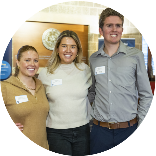 Erin Neilsen standing beside a smiling man and woman