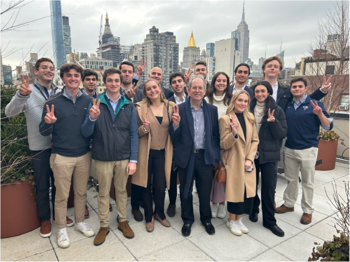 Smiling students standing in front of skyscrapers