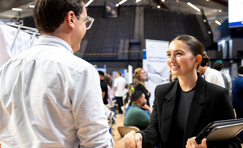 A female engineering student speaks to a potential employer.