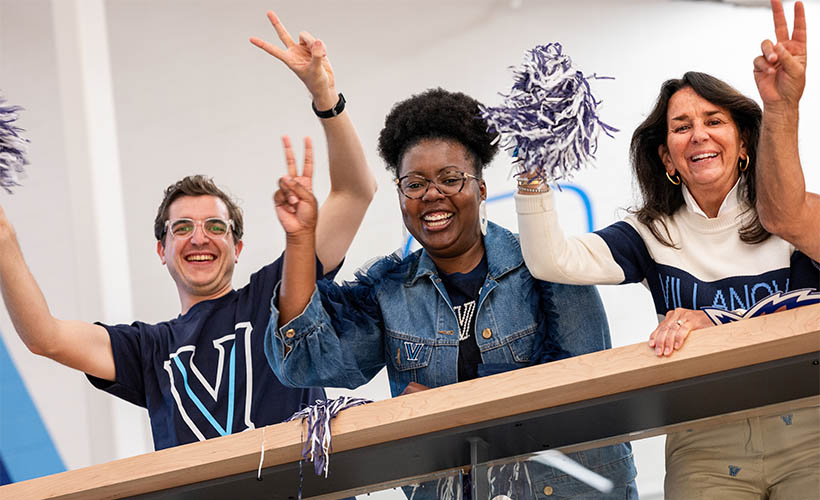 Three Villanova fans cheering in VU gear