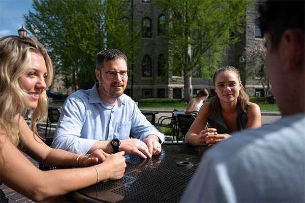 Eric Musselman chatting with students outdoors