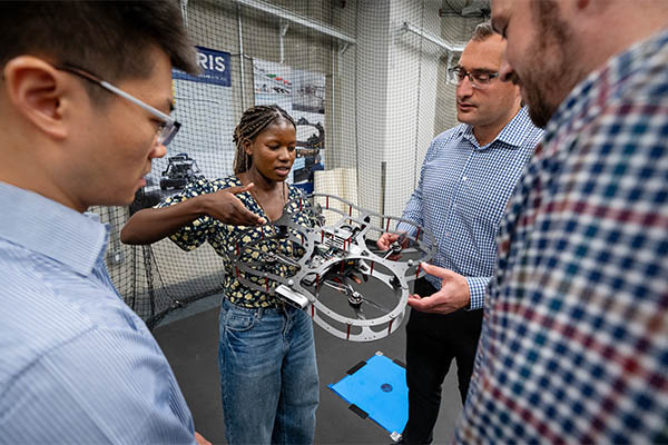 Students and professors holding a drone
