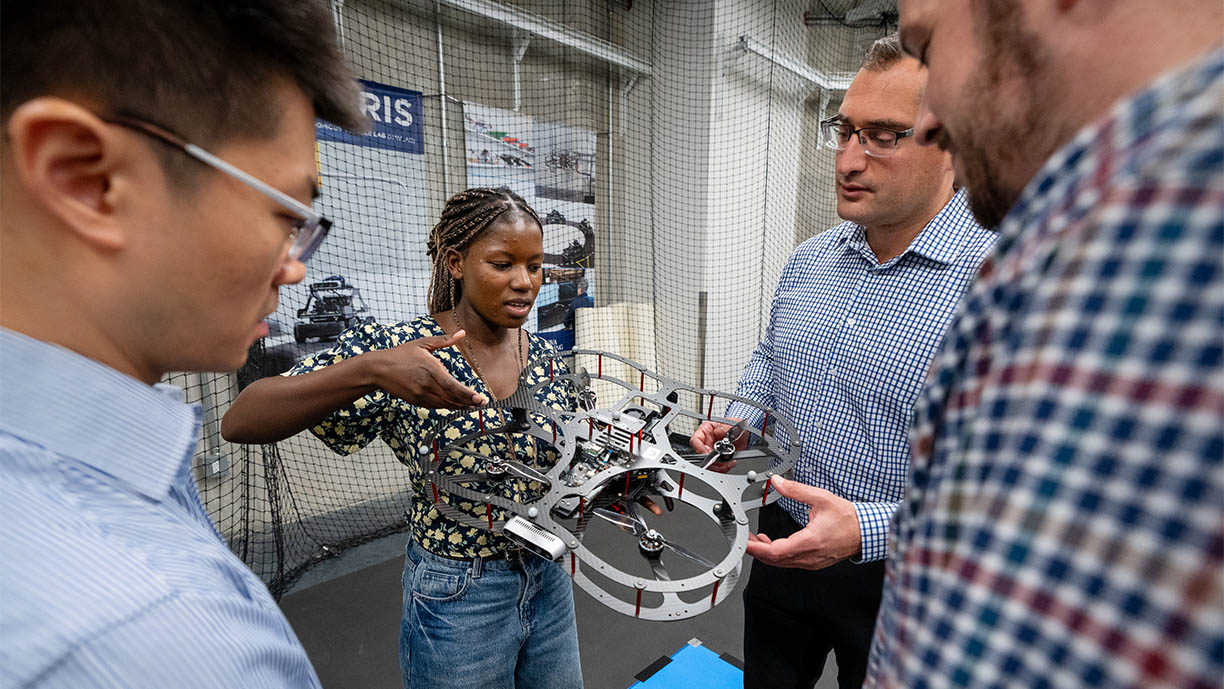 Students and professors holding a drone