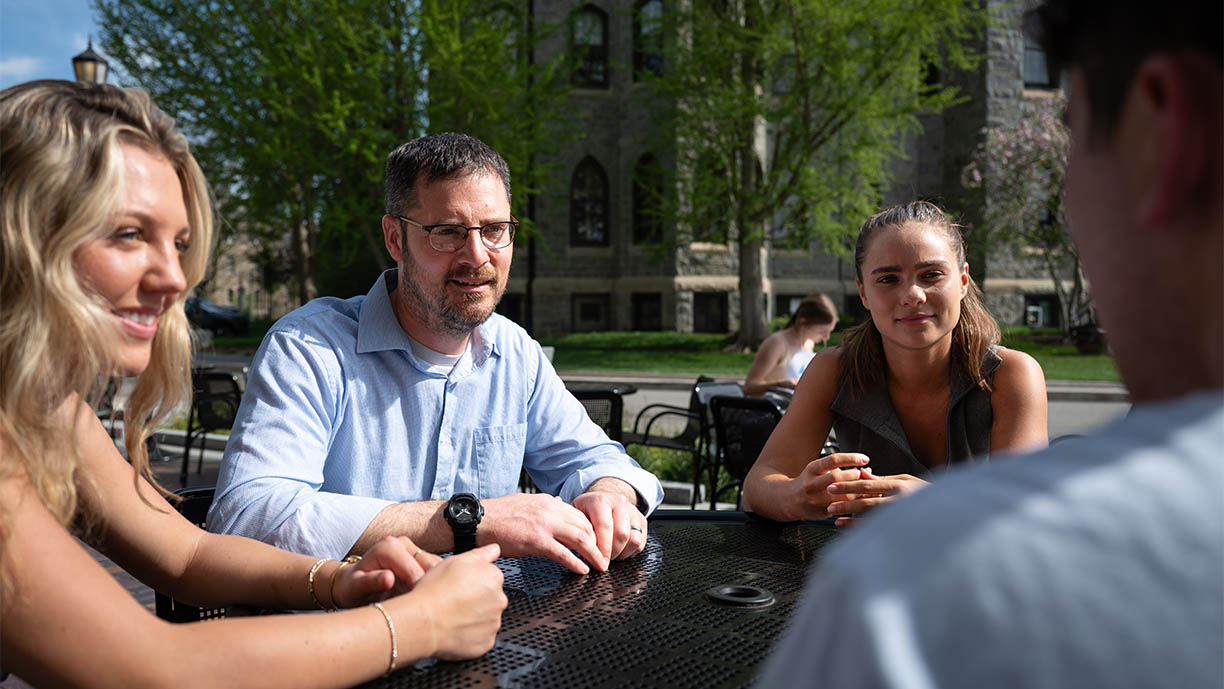 Eric Musselman chatting with students outdoors