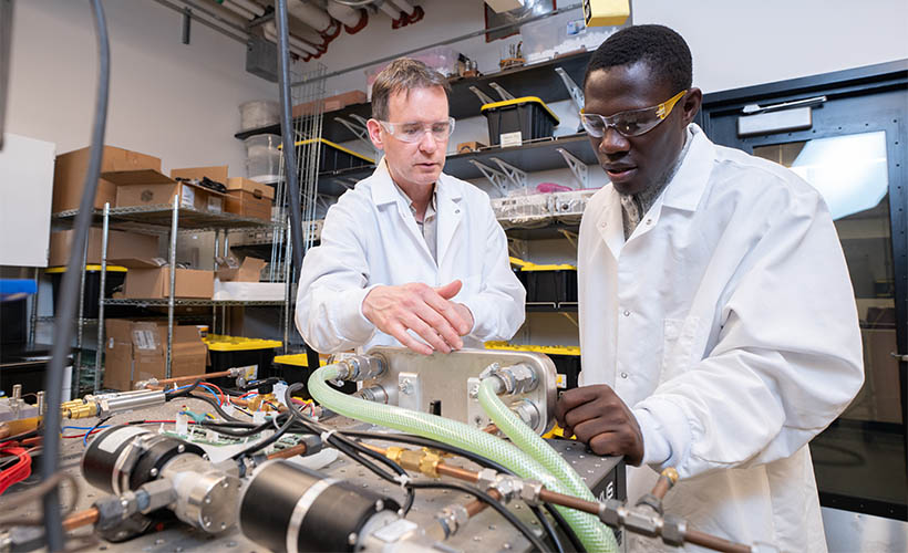 Aaron Wemhoff, PhD, and a graduate student in a Mechanical Engineering lab