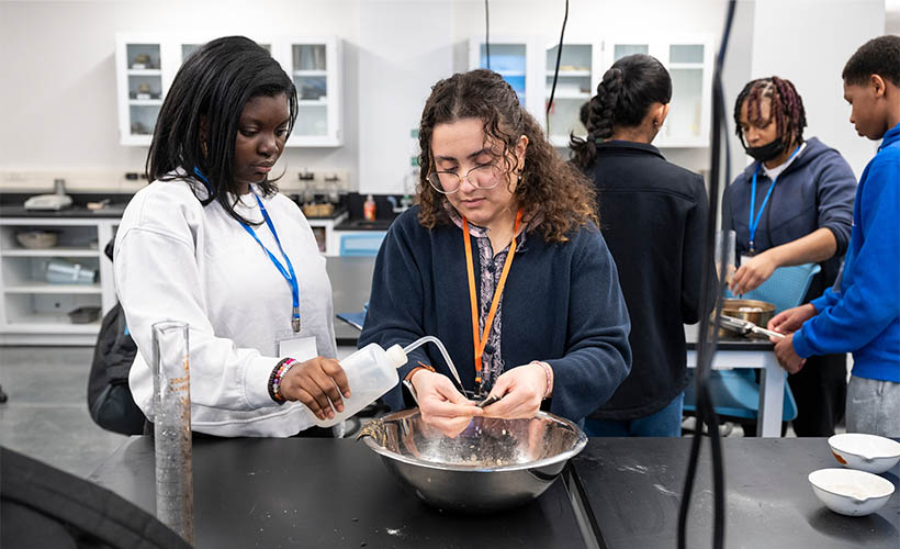 A high schooler and an engineering student in a lab