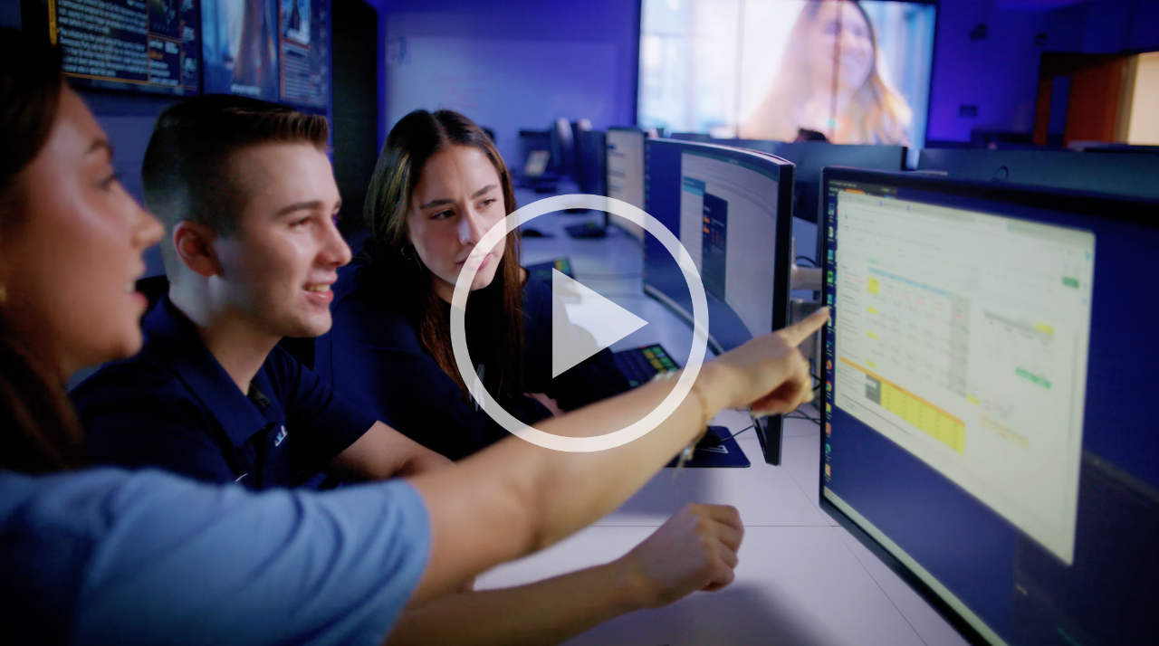 Photo of students sitting at computer, looking at data together