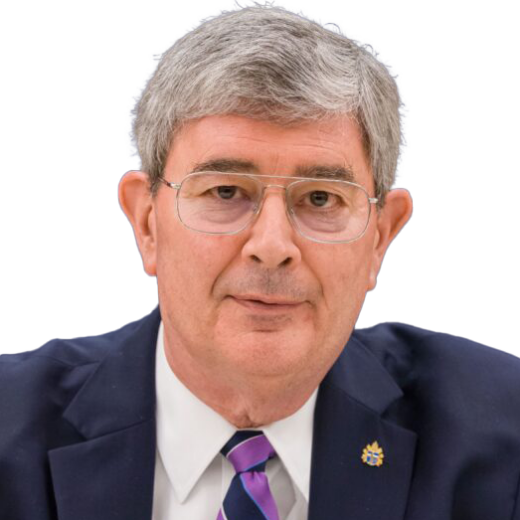 Headshot of a man wearing a navy suit, purple tie and glasses in front of a white background