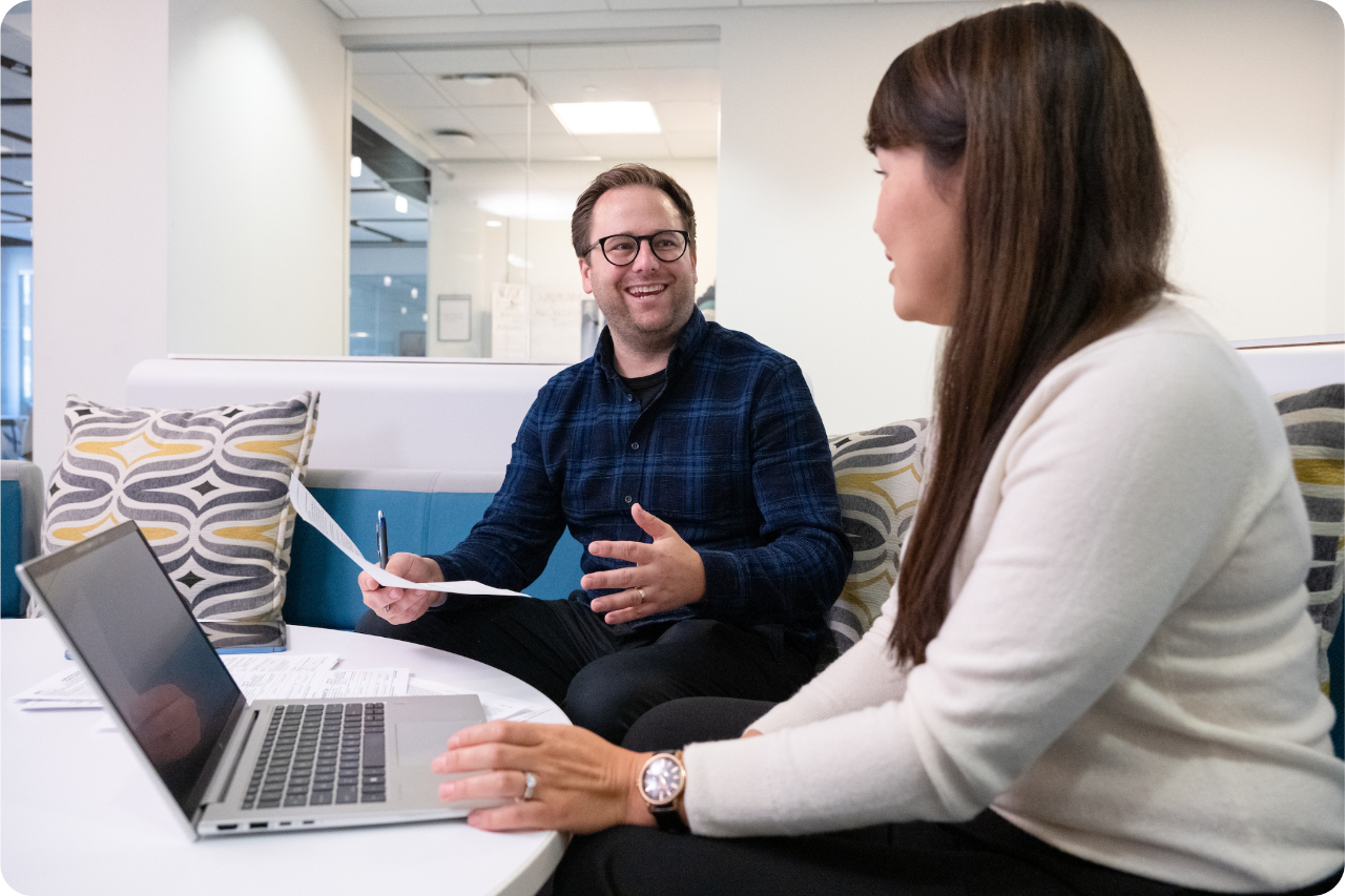 two students talking over laptop