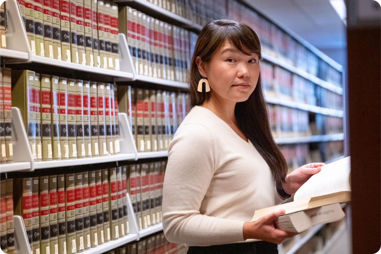 woman standing in library with open booik