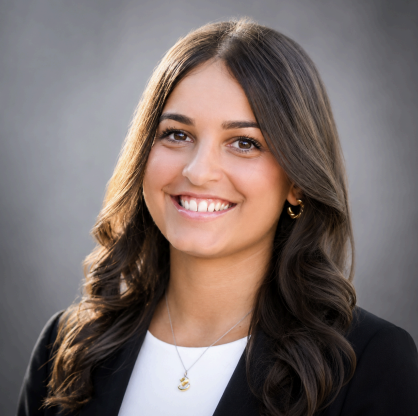 Headshot of a woman in a black blazer against a gray background
