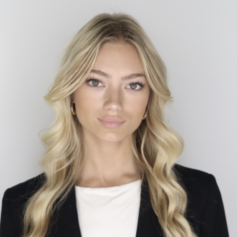 Headshot of a woman in a black blazer against a light gray background