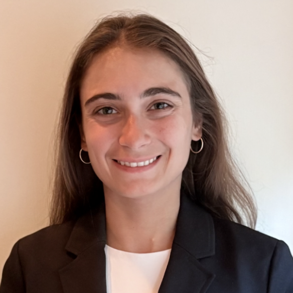 Headshot of a woman in a black blazer against a beige background