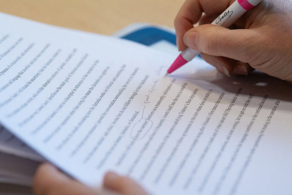 Close up of individual editing a paper.