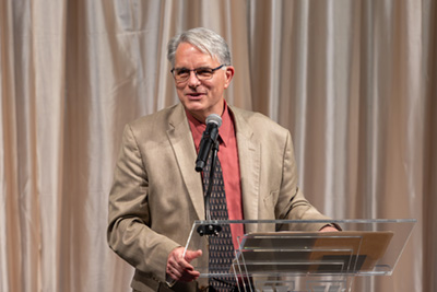 Mark Doorley, PhD, presenting at a podium.