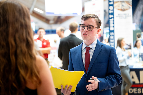 A student chats with a representative at a career fair.