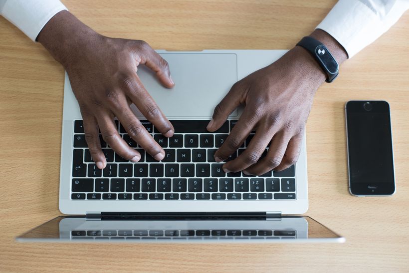 top view of a laptop with hands typing on keyboard