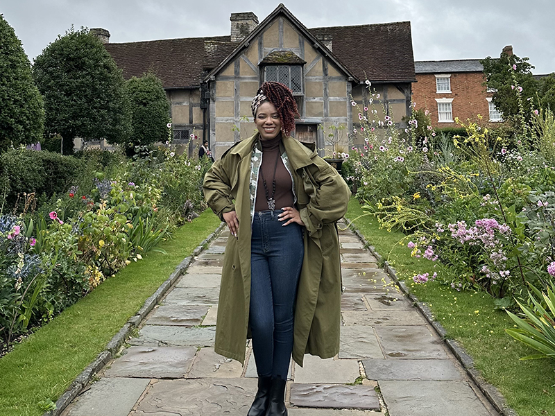 Villanova Theatre alumna Taahira Davis ’23 MA standing in front of Shakespeare's home