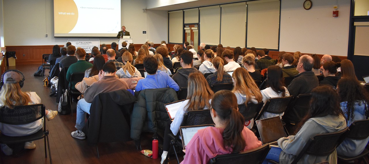 Students and faculty fill the Dougherty Hall East Lounge for the 2024 Psychological and Brain Sciences Research Colloquium.