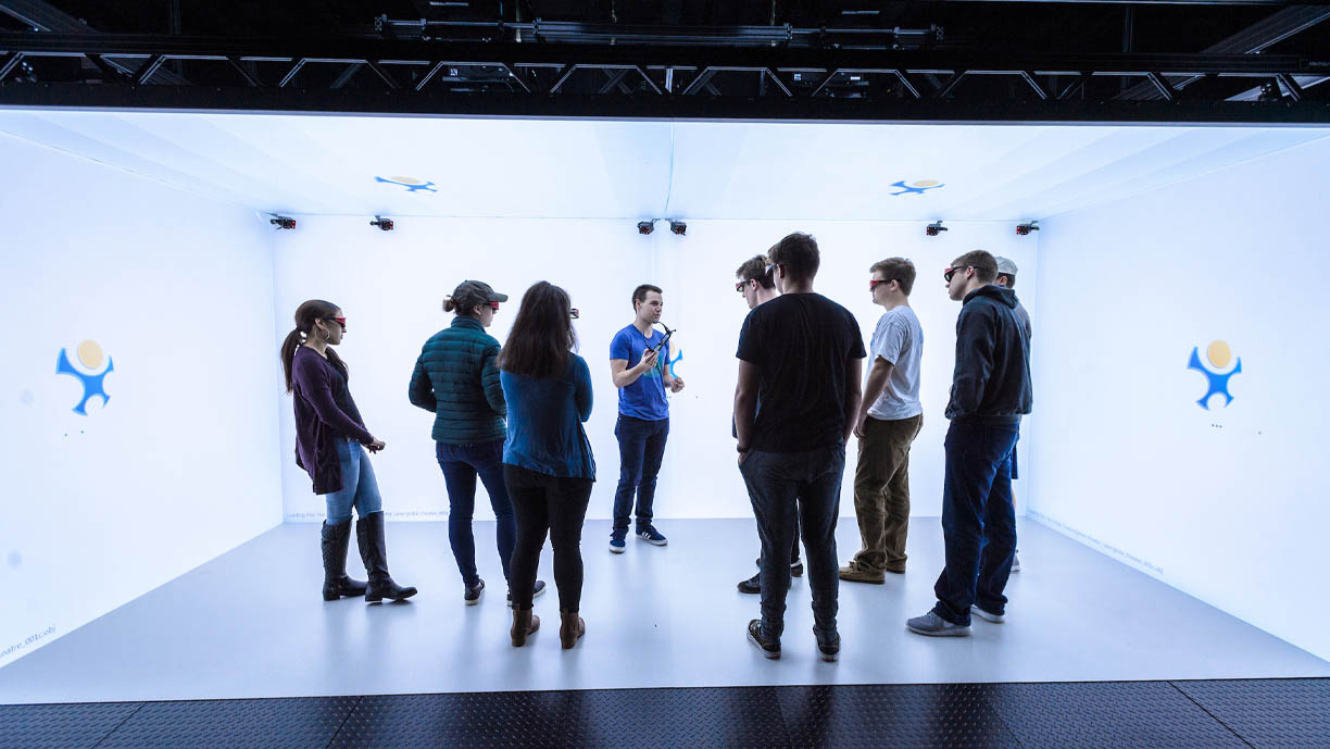 Students stand inside the virtual reality CAVE.