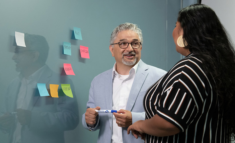 Edward Fierros, PhD, associate dean for UNITAS: Inclusive Education, talks with a student.