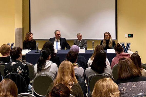 Four speakers sit a a table in front of an audience at a Villanova English publishing panel.