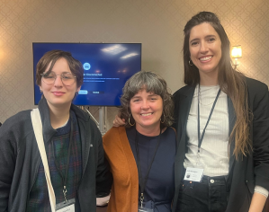 Student Jenna Kosnick, Professor Mary Mullen, and student Julia Reagan at a conference, wearing name badges