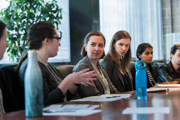 conference participants sitting at a long table and talking