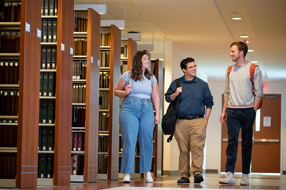 Students walk together in law library.