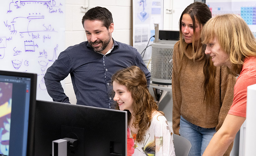 students at a computer with professor