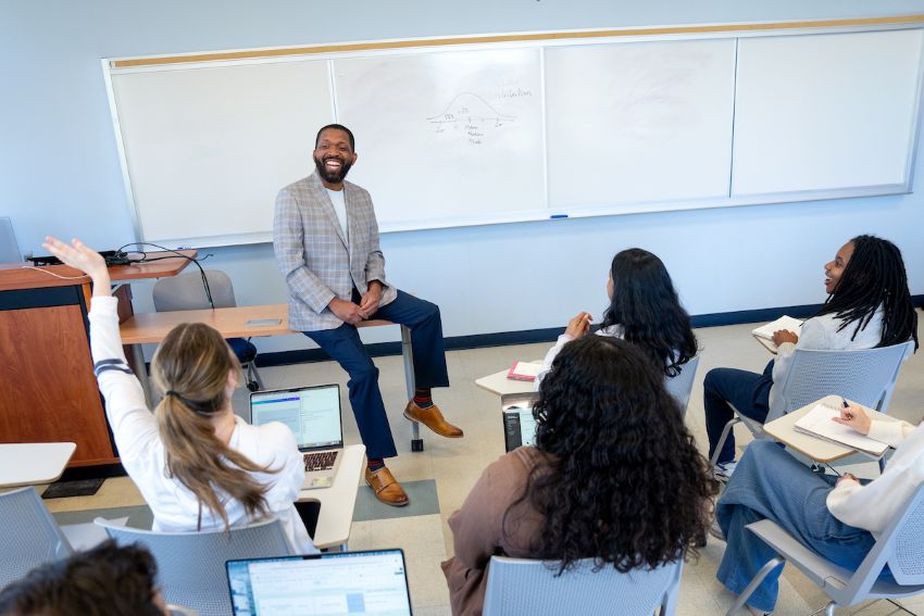 Glenn Bracey smiling in front of class