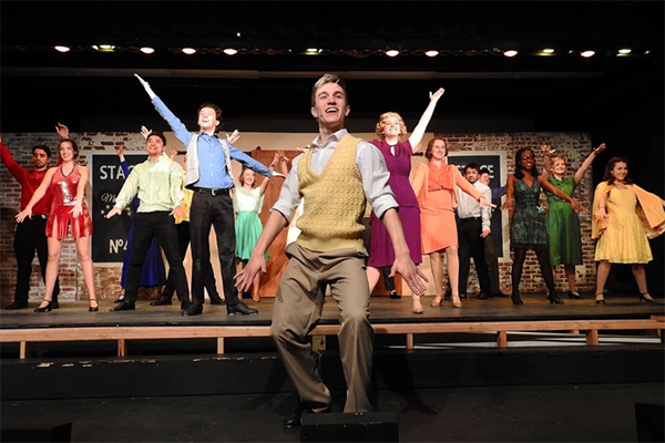 Cast standing on stage