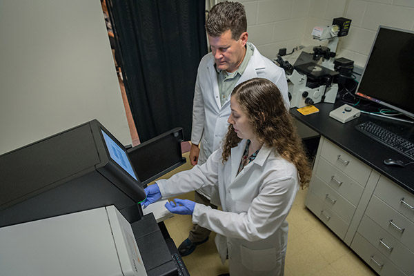 Todd Jackman, PhD, and a student work in the lab.