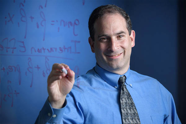 Michael Posner writes on a board.
