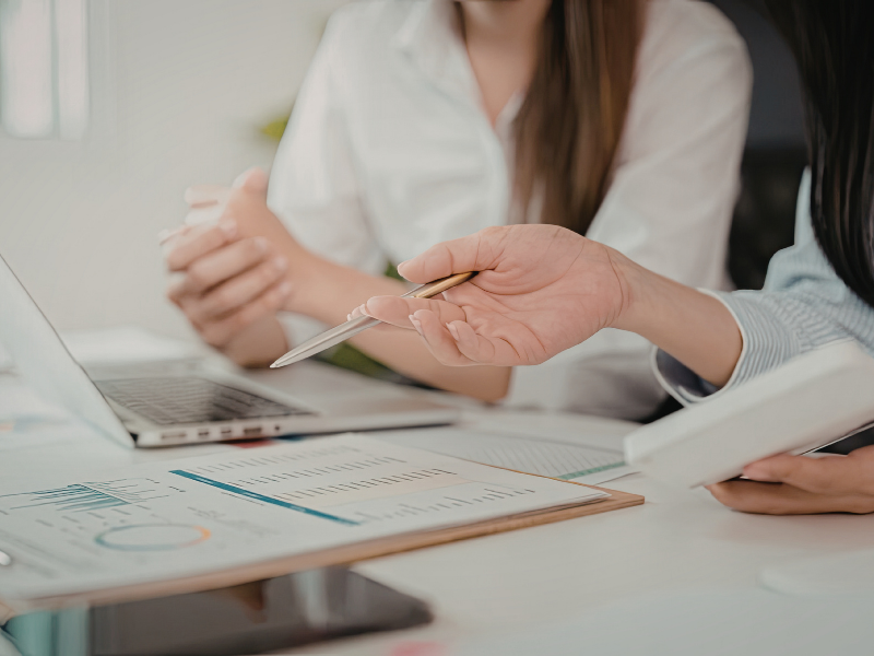 two people conversing at a desk