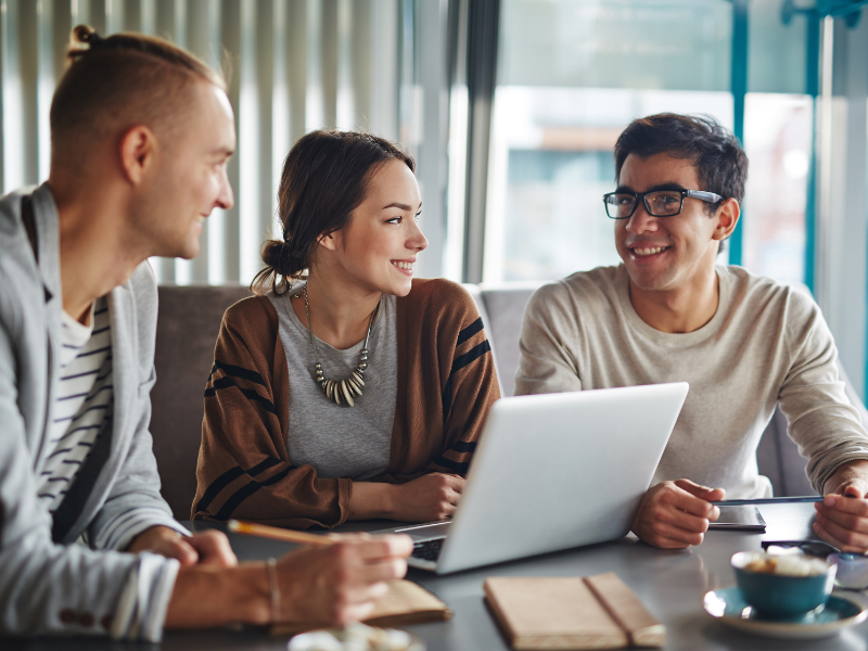 three people conversing at a table