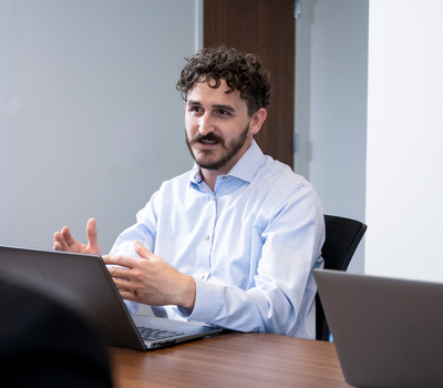 man sitting in front of a laptop and talking