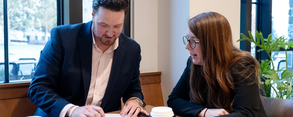 two professionals reviewing documents at a table