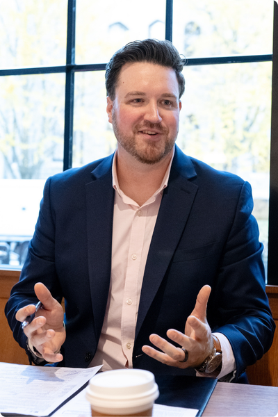 man sitting at table conversing with hands