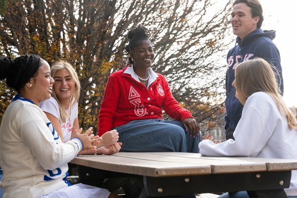 Students sitting at a table and talking outside