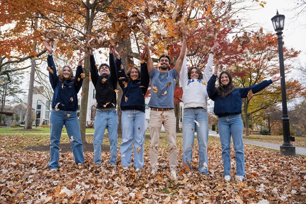 Students jumping in a pile of leaves