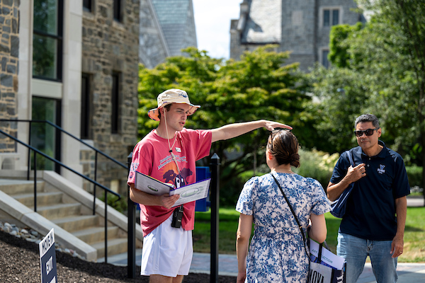 A student helps a family with directions at Orientation