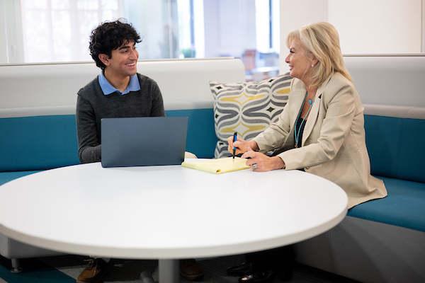 Student sitting at a table with a professor
