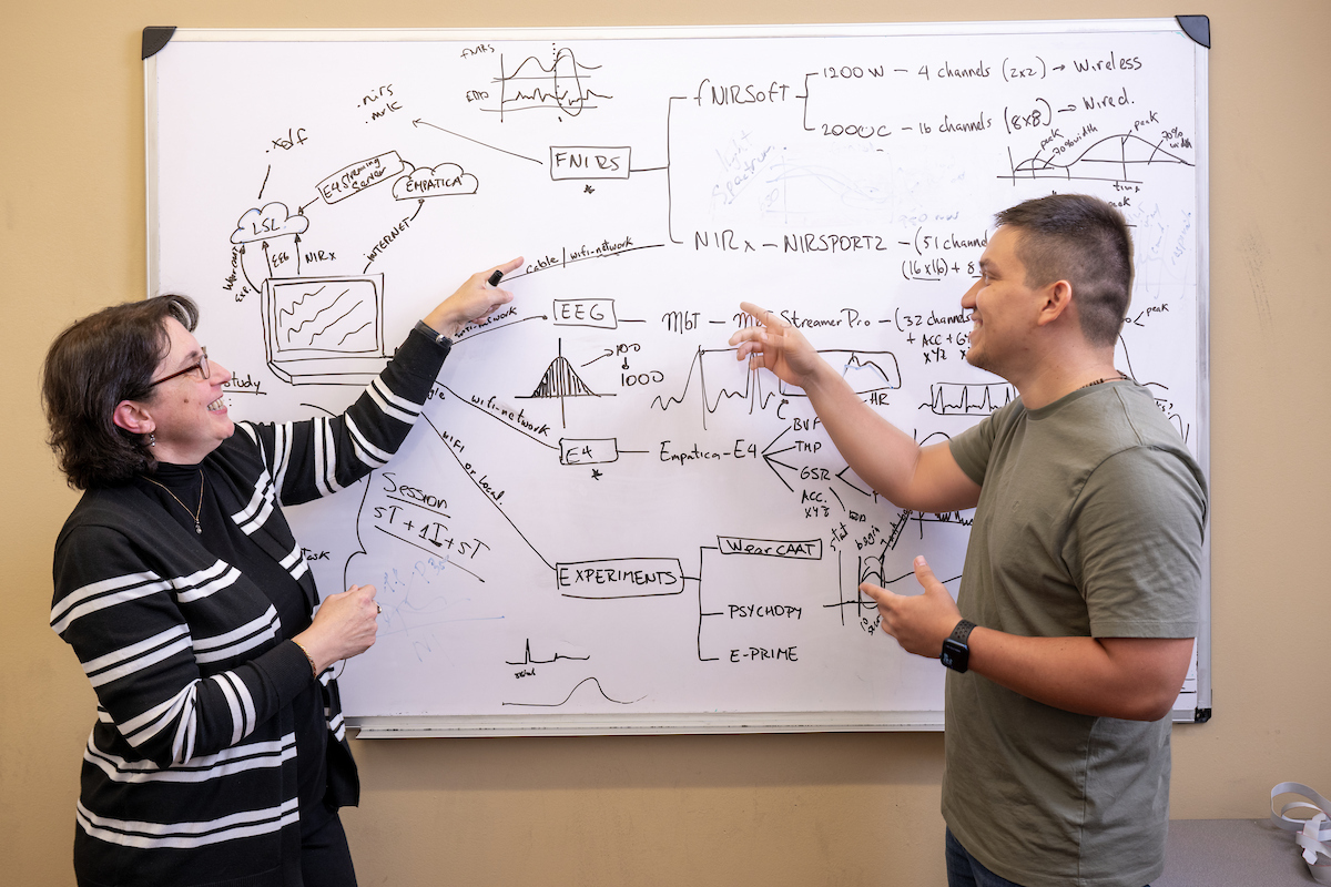 Professor and student standing in front of a whiteboard