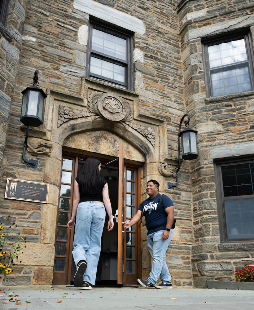 Students holding a door open for another student.